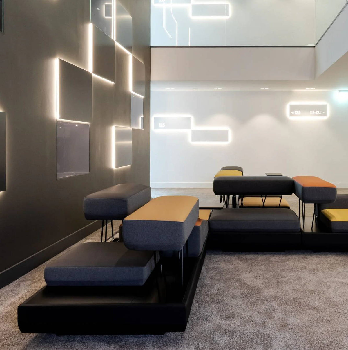 En el interior de « KPM Hotel & Residences » hay una moderna zona de descanso con elegantes asientos e iluminación ambiental.