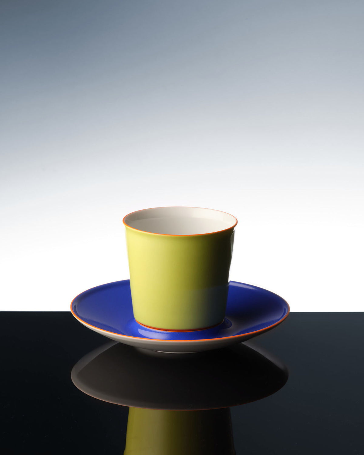Una colorida taza de avión que se refleja en una superficie oscura.