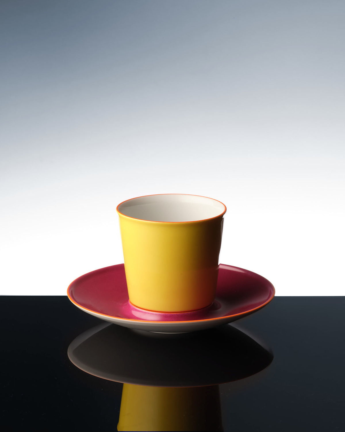 Una colorida taza de avión que se refleja en una superficie oscura.