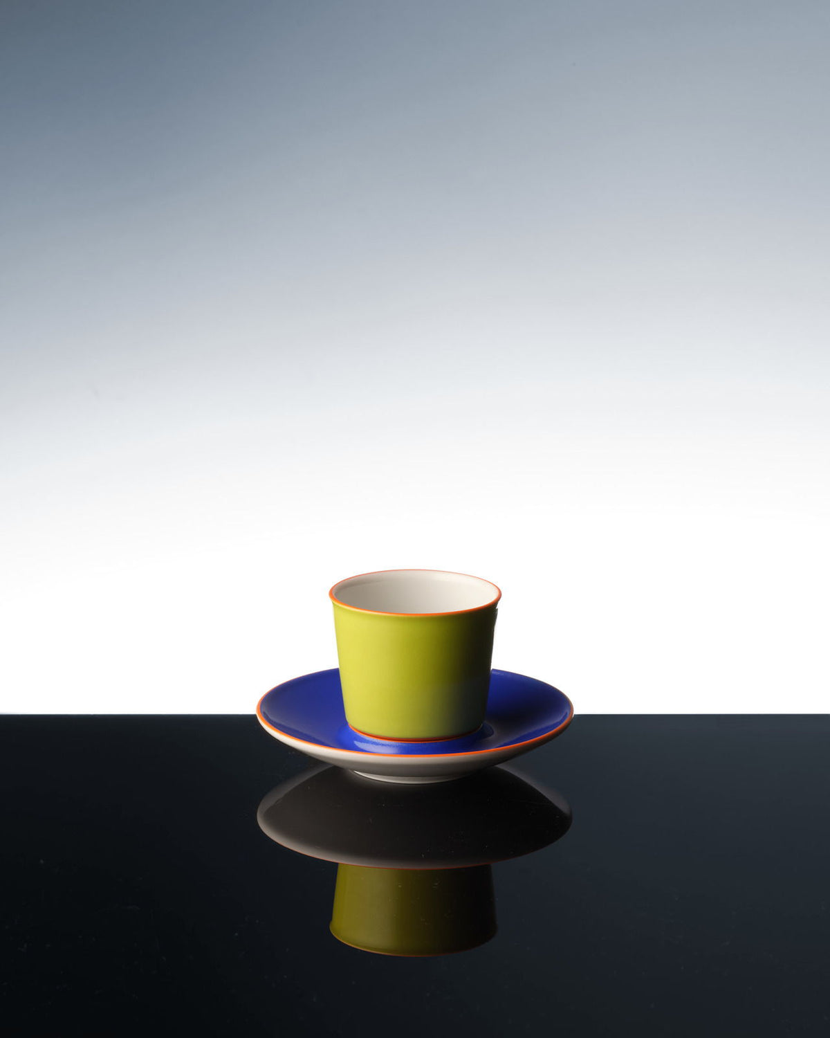 Una colorida taza de avión que se refleja en una superficie oscura.