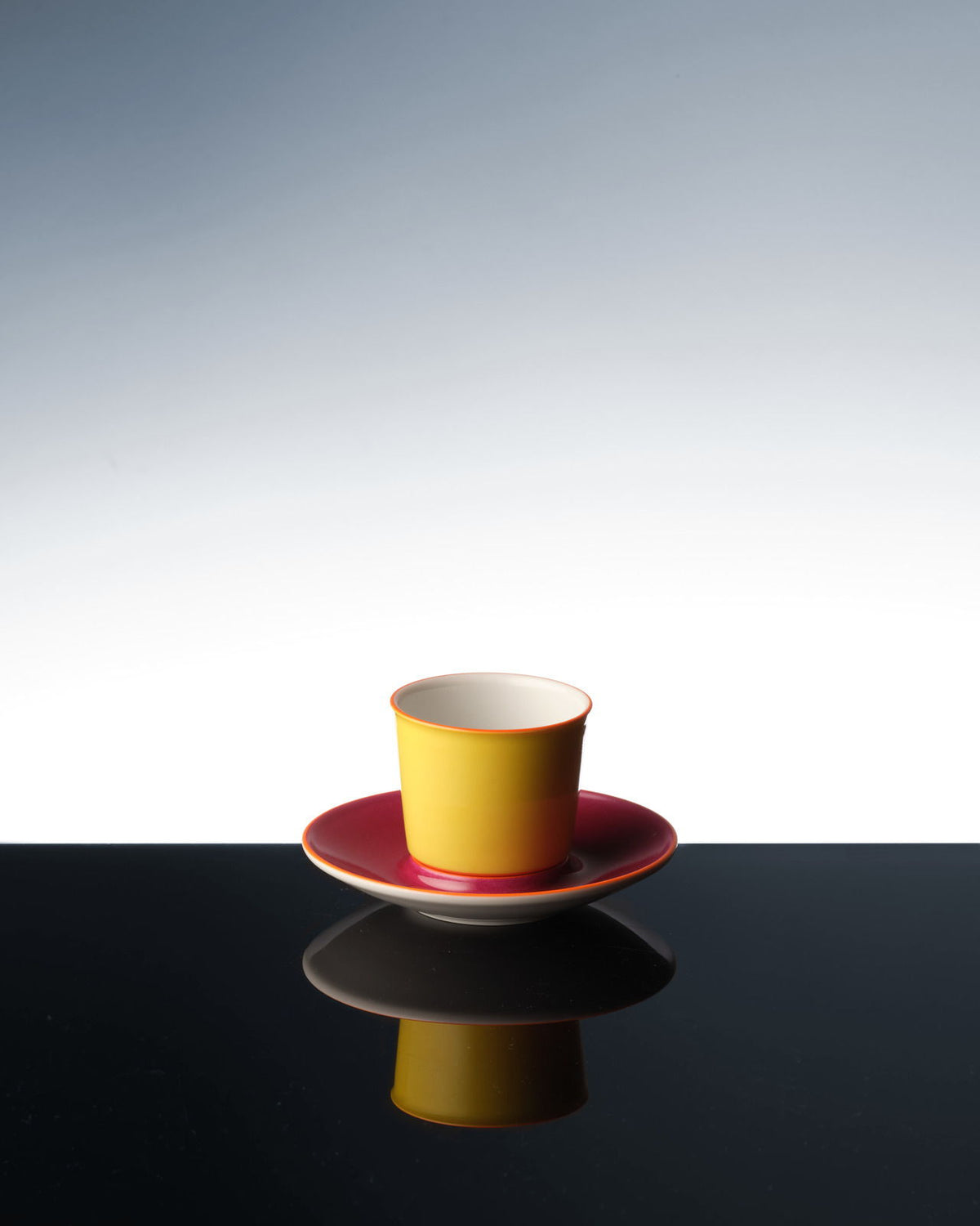 Una colorida taza de avión que se refleja en una superficie oscura.