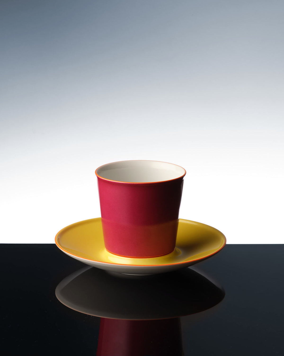 Una colorida taza de avión que se refleja en una superficie oscura.