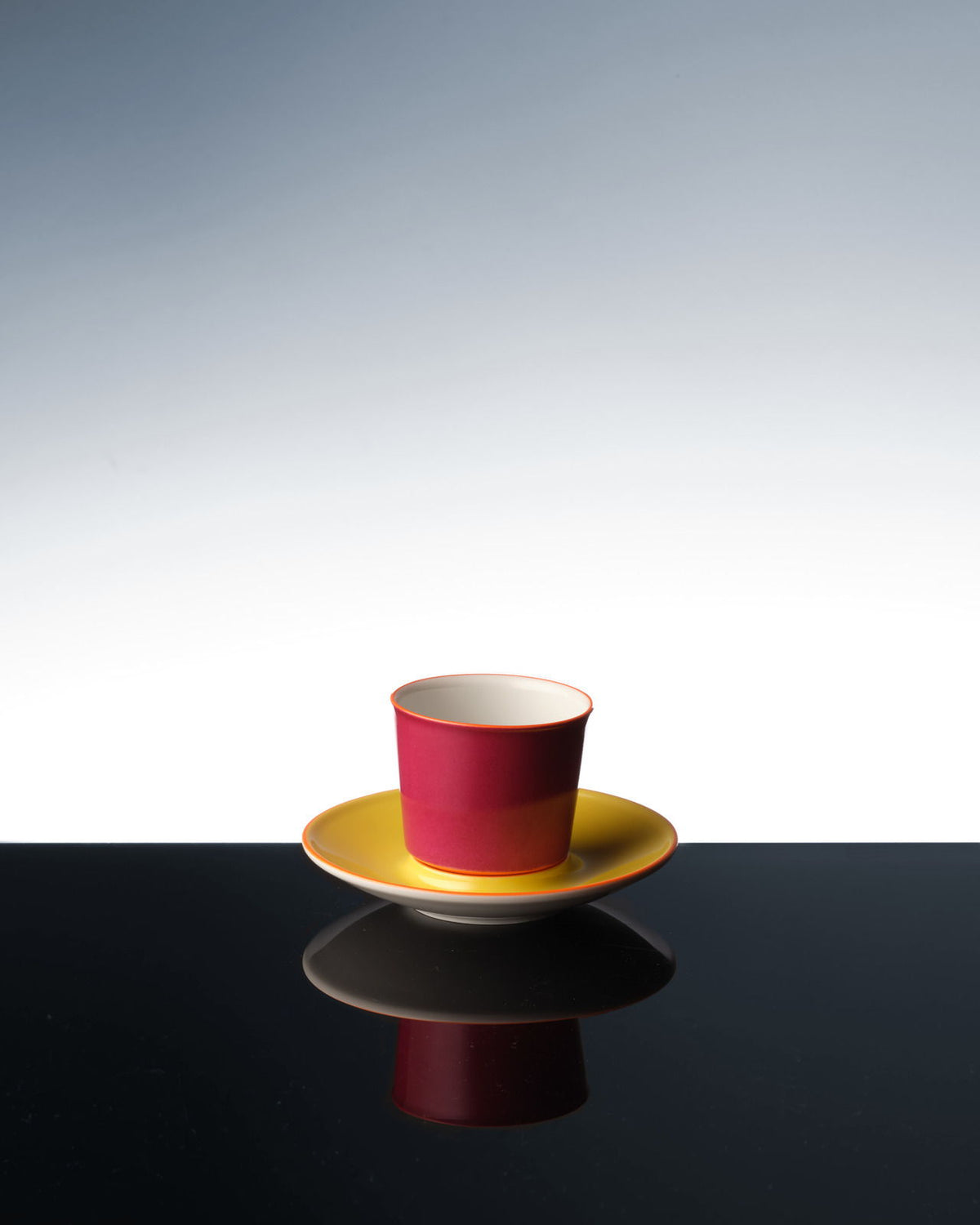 Una colorida taza de avión que se refleja en una superficie oscura.