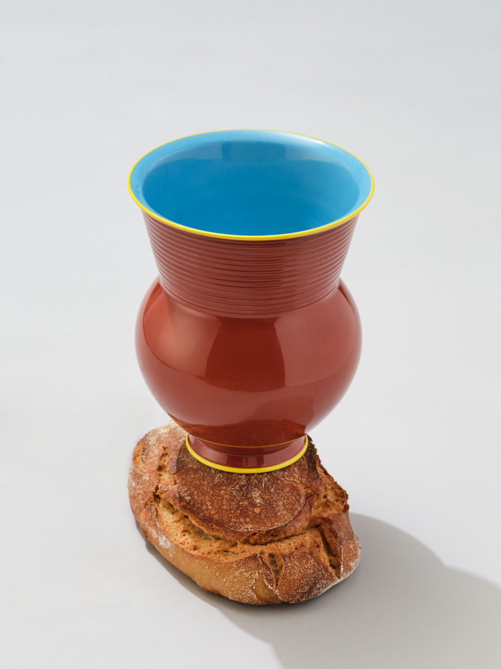 KPM+ Gisbert Pöppler Halle Jarrón con la parte superior azul, el cuerpo rojo y una base de madera.